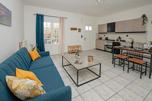 ein Wohnzimmer mit einem blauen Sofa und einer Küche in der Unterkunft Ionian Luxury Apartments in Perama