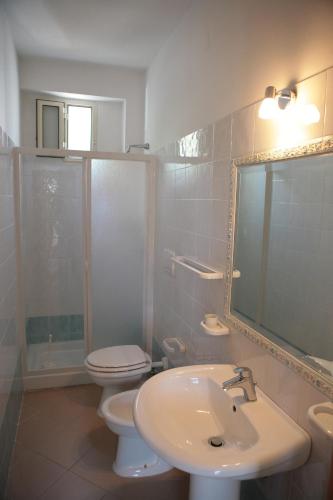 a bathroom with a sink and a toilet and a mirror at B&B Bellariva in Peschici