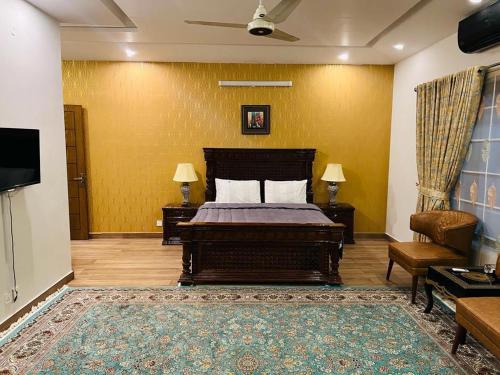 a bedroom with a bed and a couch and a tv at Pearl Executive Villa Islamabad in Islamabad
