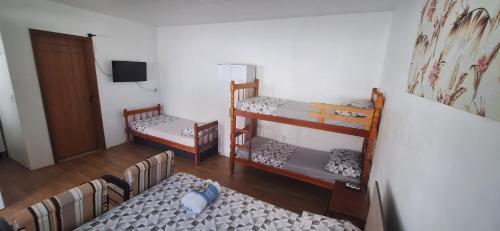 a room with three bunk beds and a bed at Pousada Felix in São Gabriel
