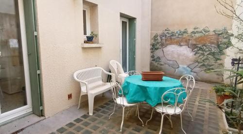 une petite table et des chaises sur la terrasse dans l'établissement Mol, à Sérignan