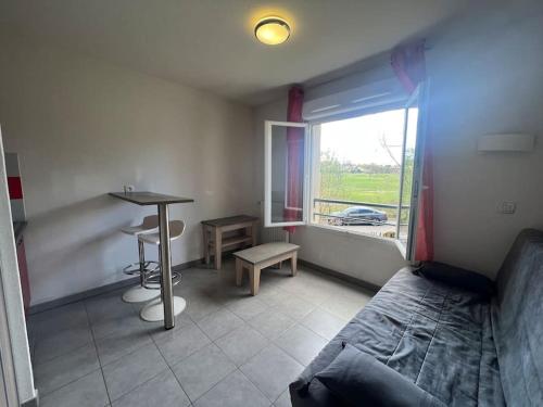 une chambre avec un lit, une table et une fenêtre dans l'établissement Le Curaçao, à Juvignac