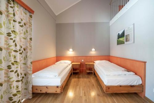 a room with two beds and a curtain at JUFA Hotel Hochrindl in Hochrindl