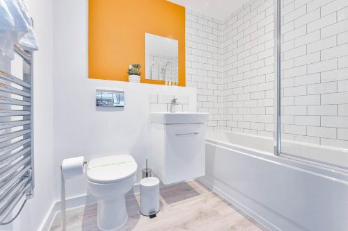 a bathroom with a toilet and a sink and a tub at StayZeni, Hardwick House Derby Modern 1 Bed Flat in Derby