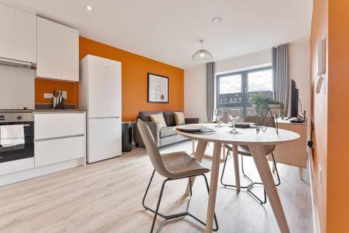 a kitchen and living room with a table and chairs at StayZeni, Hardwick House Derby Modern 1 Bed Flat in Derby