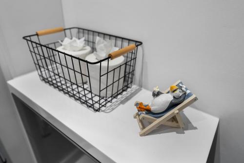 a toy penguin sitting on a chair with a basket of toilet paper at Luxurious 1 Bed Stylish Apt, Southampton in Southampton
