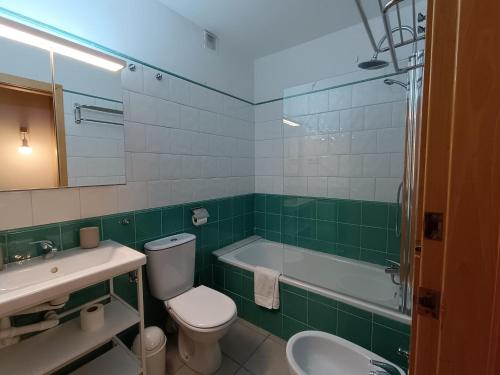 a bathroom with a toilet and a sink and a tub at Inmocyma Tu Refugio en Benasque in Benasque