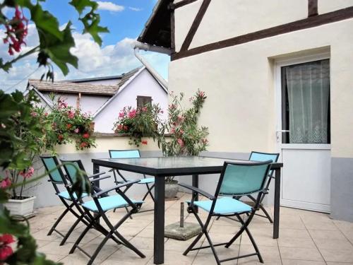 un patio con mesa negra y sillas en Maison de 3 chambres avec terrasse amenagee et wifi a Ingersheim, en Ingersheim