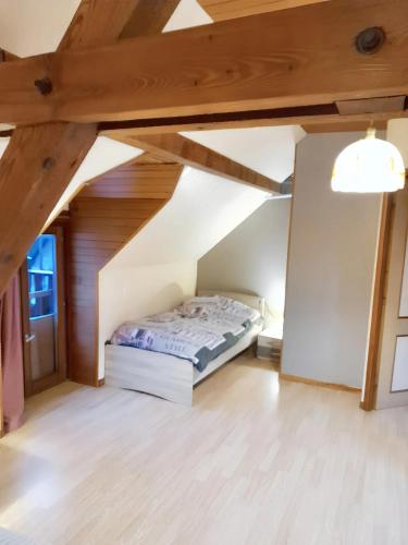 une chambre avec un lit dans un grenier dans l'établissement Maison spacieuse à Ingersheim avec vue sur la montagne, à Ingersheim