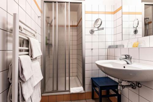 a bathroom with a sink and a shower at JUFA Hotel Hochrindl in Hochrindl