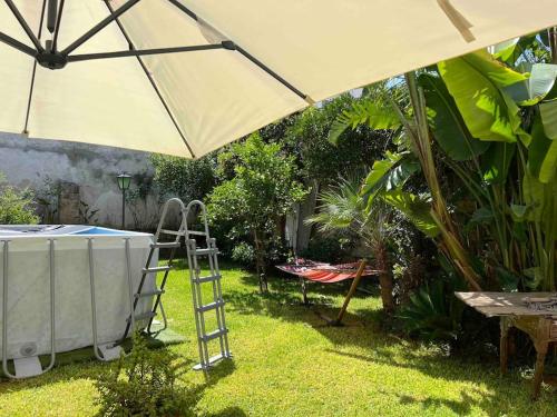 um guarda-chuva grande e uma escada debaixo de uma mesa em Appartamento esclusivo con giardino em Neviano