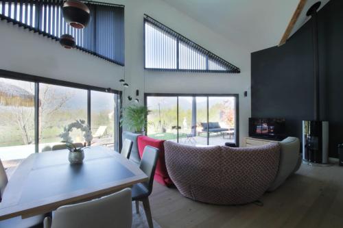 un salon avec une table et des chaises dans l'établissement Magnificent villa with heated pool air conditioning, à Viviers-du-Lac