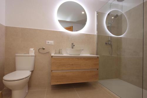 a bathroom with a toilet and a sink and mirrors at Villa Alegre in Pollença