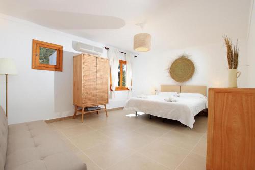 a white bedroom with a bed and a window at Villa Alegre in Pollença