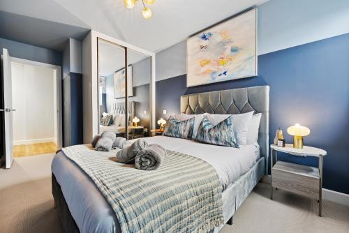 a bedroom with a large bed with blue walls at Luxury 1-Bedroom Stylish & Cosy Apartment, Central Southampton! Stylish abode Sleeps 4, Great Location! - by Blue Puffin Stays in Southampton