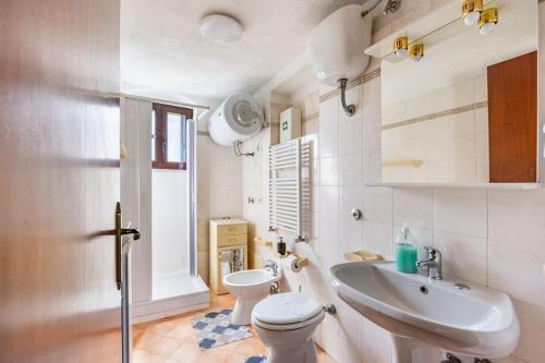 un bagno con un water bianco e un lavandino di Country Chic Antico Casale - piscina idromassaggio lettini, solarium, cinema experience, wifi, parcheggio a Caiazzo