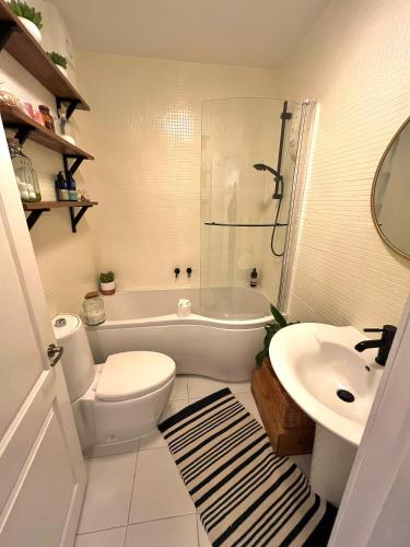 a bathroom with a toilet and a tub and a sink at The Terrace Garden Flat in Bournemouth