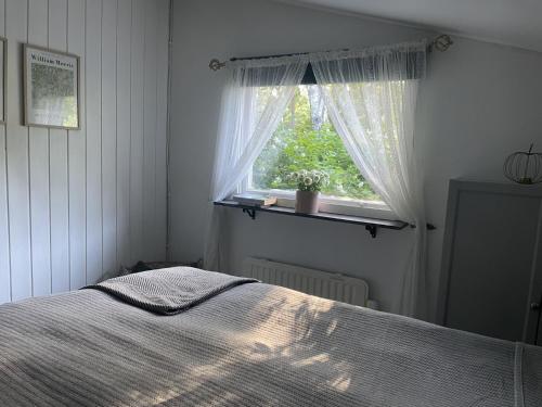 a bedroom with a bed and a window at Genuine 100 year old countryside cottage in Rimbo
