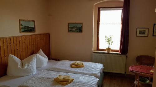 a bedroom with two beds with towels on them at Pension & Gasthaus Nostalgie in Chemnitz