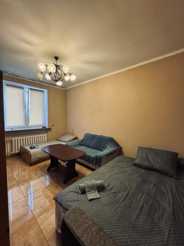 um quarto com duas camas e uma mesa em Apartament Wlodzimierza bilana 4/5 em Przemyśl
