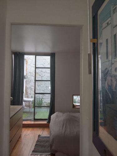 a bedroom with a bed and a large window at Paris, central et calme in Paris