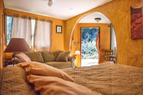 a bedroom with a bed and a couch and a window at Hacienda Hideaway + Mountain View, Creek & Trails in Topanga