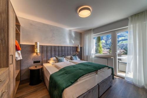 Un dormitorio con una cama grande y una ventana en Familien-Wellness Residence Tyrol, en Naturno