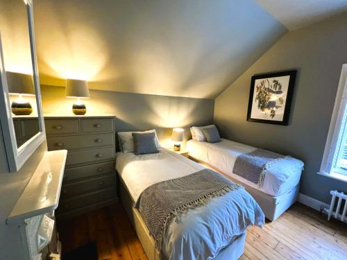 a bedroom with two beds and a dresser at Belverdere Cottage - Pet friendly in Ventnor