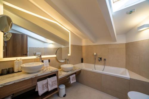 a bathroom with two sinks and a bath tub at Familien-Wellness Residence Tyrol in Naturno