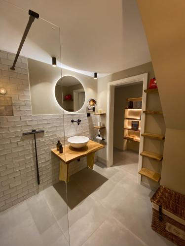 a bathroom with a sink and a glass shower at Cosy Getaway in Gostinjac