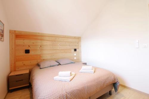 a bedroom with a bed with two towels on it at Pretty new and comfortable house between towns and lakes in Voglans