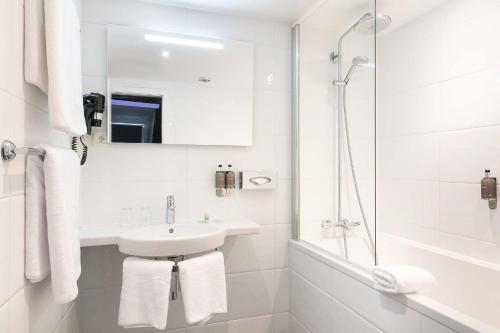 a white bathroom with a sink and a shower at Hôtel de l'Europe by HappyCulture in Strasbourg