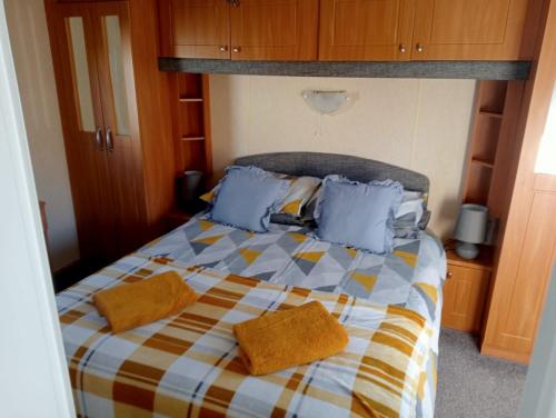 アベルゲレにあるModern 2 Bedroom Static Caravan - Lyons Kingsley Holiday Park - Pensarn, Abergele - Pet Friendlyのベッドルーム(青い枕のベッド1台付)