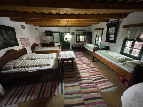 a large room with three beds and a rug at Erdélyi parasztház in Veţca