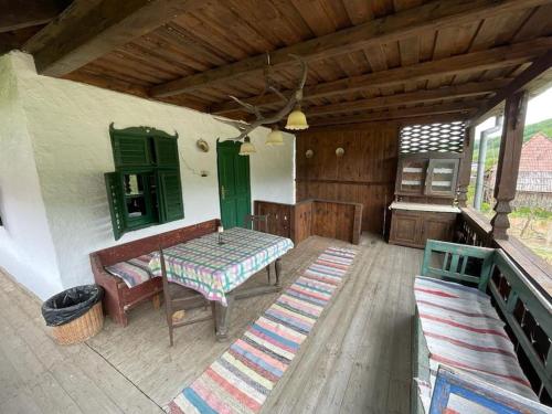 a patio with a table and a bench on a porch at Erdélyi parasztház in Veţca