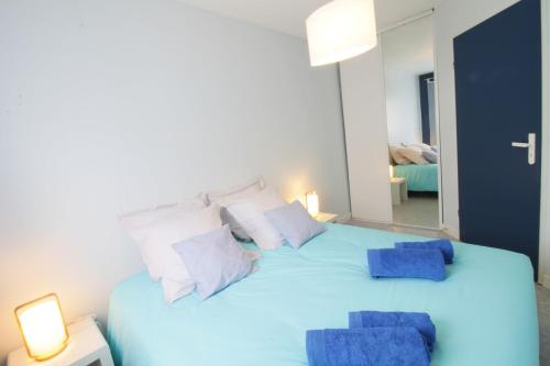 1 cama azul grande con 2 almohadas azules en Comfortable T3 at the foot of the Castle of Chambéry! en Chambéry