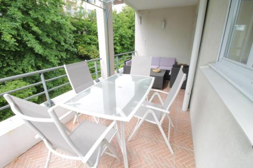 a balcony with a white table and chairs at Comfortable T3 at the foot of the Castle of Chambéry! in Chambéry