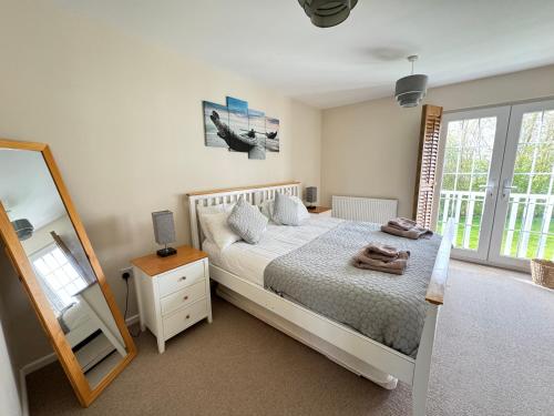 Кровать или кровати в номере Cerney House, Windrush Lake, Cotswold Water Park