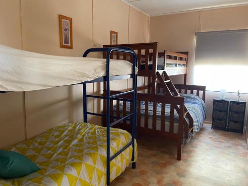 two bunk beds in a room with a classroom at Bonnie Bliss - James Well in Perara