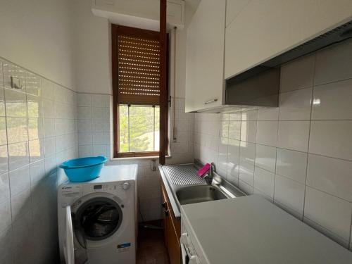 Il comprend une cuisine équipée d'un lave-linge et d'un évier. dans l'établissement Ampio appartamento Marina di Arbus, à Arbus