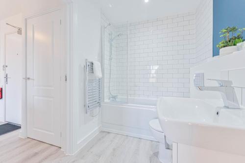 a white bathroom with a toilet and a sink at Lovely 2 Bed Apartment Nightingale Quarter Derby in Derby