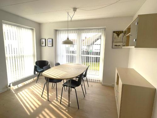 uma cozinha e sala de jantar com mesa e cadeiras em Byhus centralt på Læsø em Vesterø Havn
