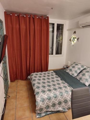 - une chambre avec un lit et un rideau orange dans l'établissement Studio, à Saint-Loubès