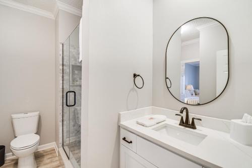a white bathroom with a sink and a mirror at Dolphin Harbor Orange Beach Condo w/ Beach Access! in Orange Beach