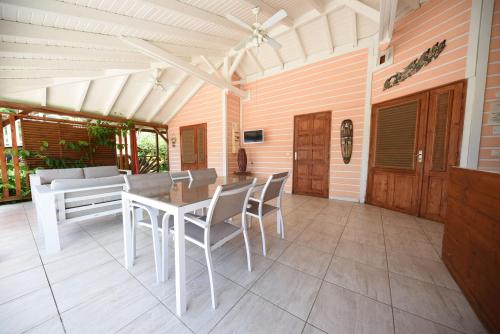 a patio with a table and chairs and a couch at Gite Hibiscus in Pointe-Noire