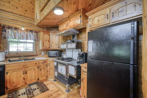 a kitchen with a black refrigerator and wooden cabinets at Uncle Terry's Cabin in Rigby