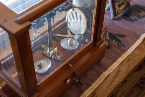 a wooden table with a glass case with clocks in it at Uncle Terry's Cabin in Rigby