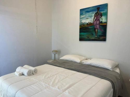 a bed in a room with a painting on the wall at Ache Pa Ti I Isabela in Isabela