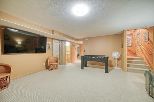 a room with a ping pong table and stairs at Uncle Terry's Cabin in Rigby