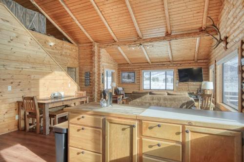 a log cabin kitchen and living room with a couch at Trout Trap at Henry's Lake in Island Park